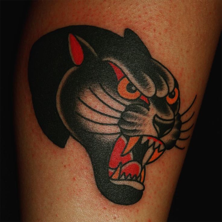 a black and red tattoo with a tiger's head on it, showing its teeth