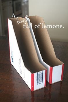 two empty boxes sitting on top of a wooden table next to an open box with the words, a book full of lemons