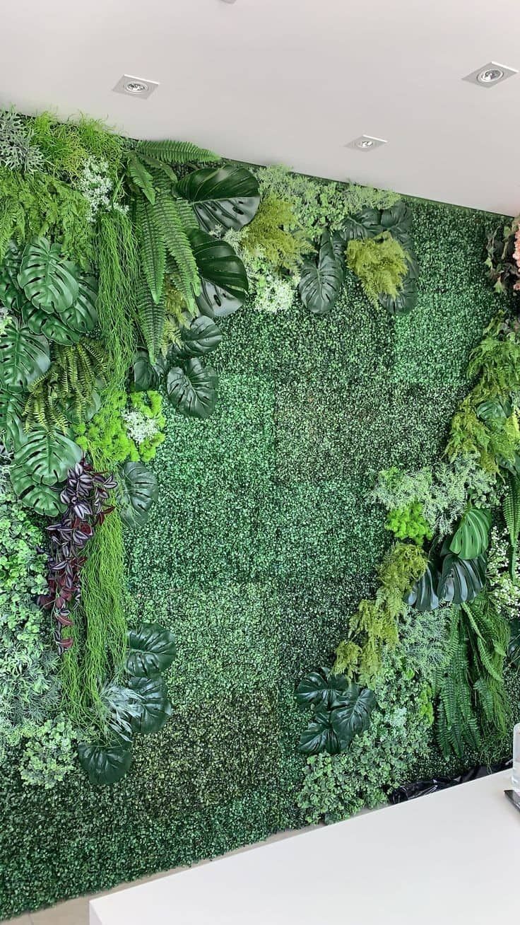 a green wall with lots of plants on it