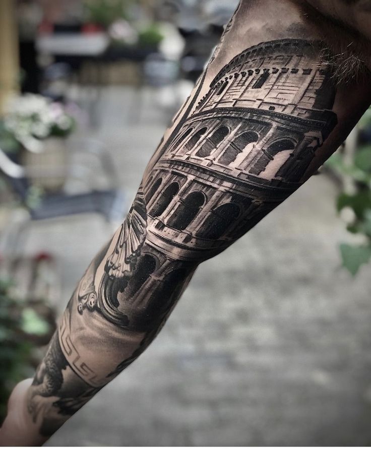 a man's arm with a black and grey tattoo on it