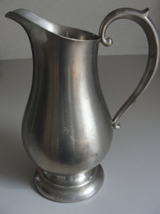 a silver pitcher sitting on top of a table