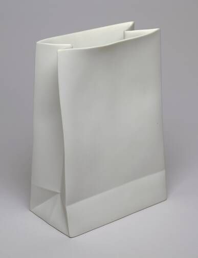 a white paper bag sitting on top of a gray surface with the bottom half open