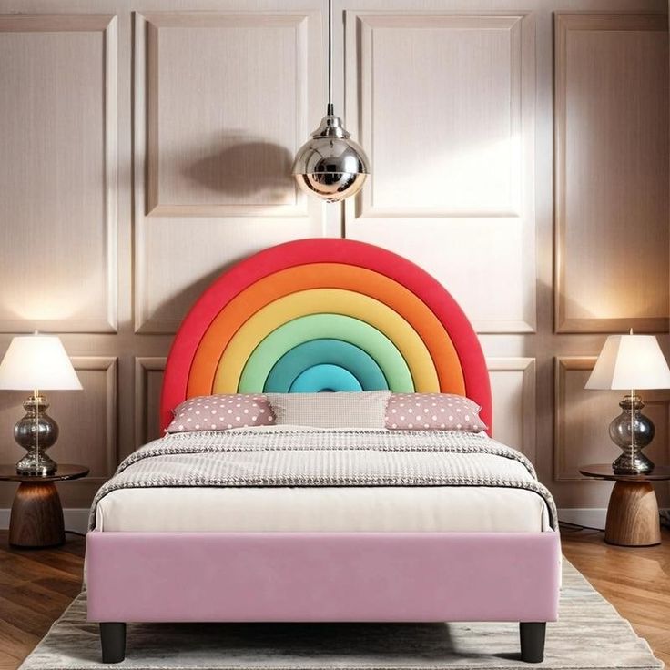 a bed with a rainbow colored headboard and foot board next to lamps on either side of the bed