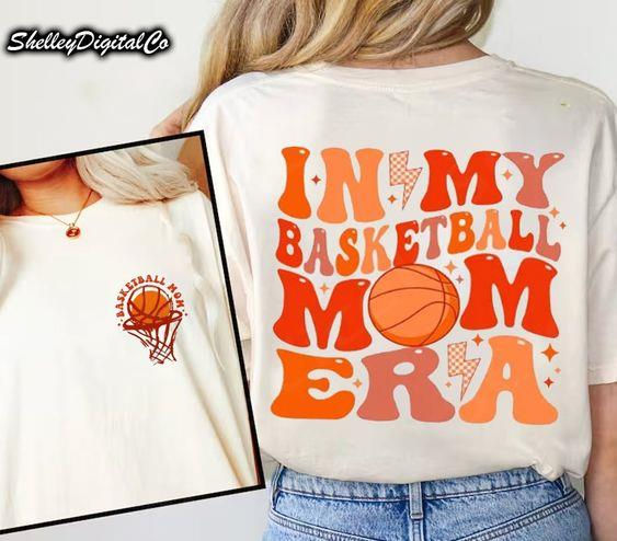 a woman wearing an orange and white shirt with the words in my basketball mom era on it