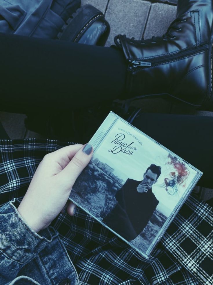 a person sitting on the ground holding an album