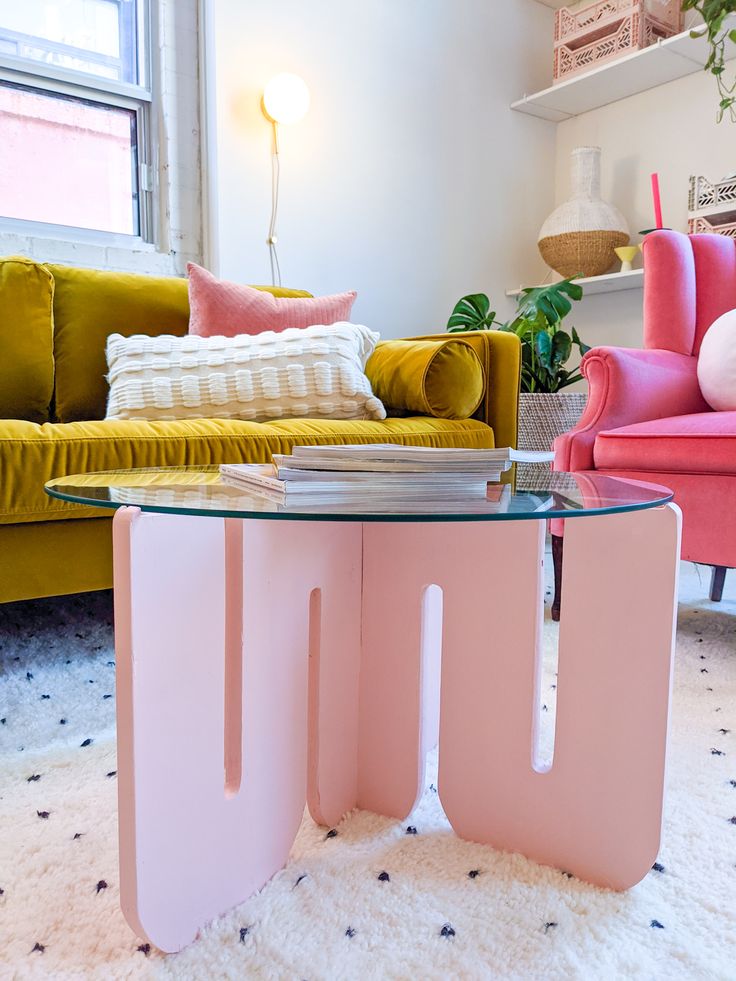 a living room filled with furniture and a pink table in front of a yellow couch