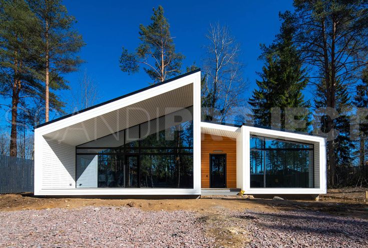 a small white house sitting on top of a gravel field