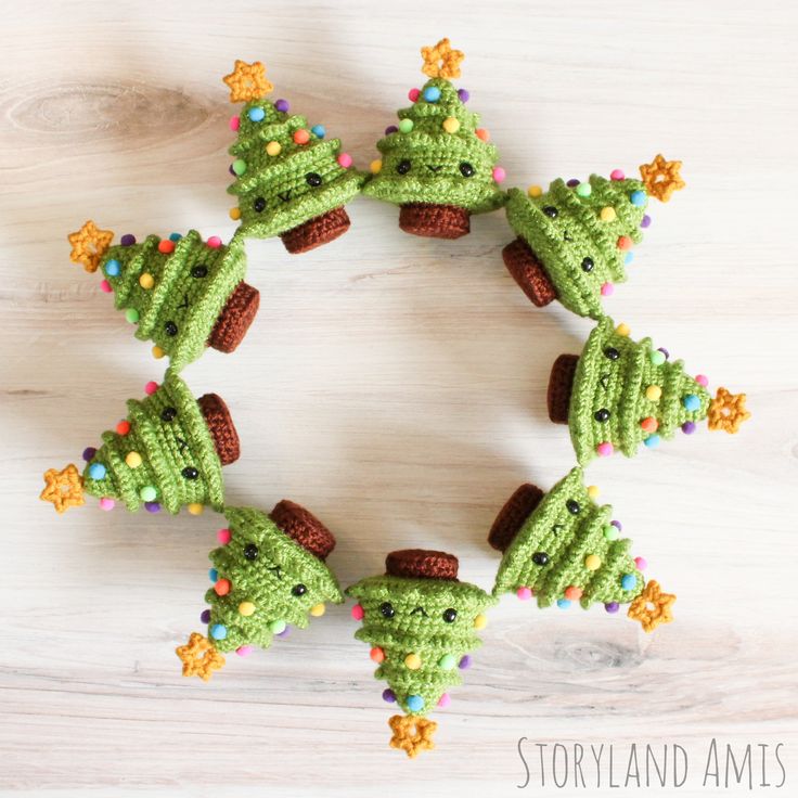 crocheted christmas tree ornaments arranged in the shape of a star