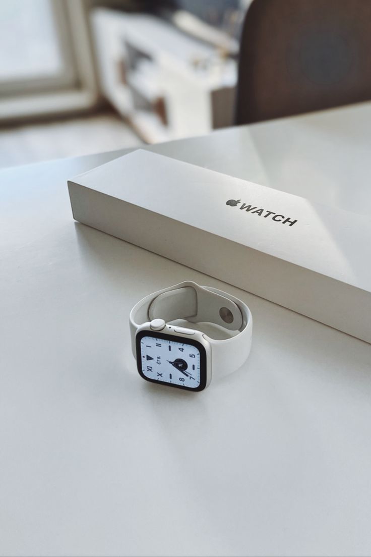 an apple watch sitting on top of a table next to a box and pen holder