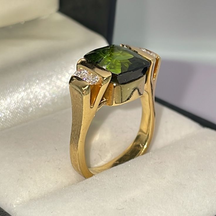 Stunning, One Of A Kind, Vintage Estate Ring. Substantial And Modern. Solid 18k Yellow Gold. Natural Green Tourmaline And Diamonds. Features A Fancy, Abraded, Cushion Cut Green Tourmaline. Moderate Hue And Intensity, Measuring 9.35 Mm X 8 Mm In Channels Setting. Sides Feature Four Natural, Round, Brilliant Cut Diamonds. Estimated Color G H , And Vs To Si Clarity. Estimated .28 Tcw. Please See All Photos For Details. Exceptionally Well Made. Very Rare Opportunity. I Don’t Need To Sell. Price Is Final, No Trades. Luxury Tsavorite Gemstones For Anniversary, Luxury Peridot Rings With Accent Stones, Elegant Tsavorite Gemstones For Anniversary, Luxury Yellow Gold Peridot Jewelry, Baguette Cut Tourmaline Jewelry For Weddings, Formal Peridot Diamond Ring In Yellow Gold, Elegant Gemstones With Bezel Setting For Formal Occasions, Elegant Bezel Set Gemstones For Formal Occasions, Elegant Formal Gemstones With Bezel Setting