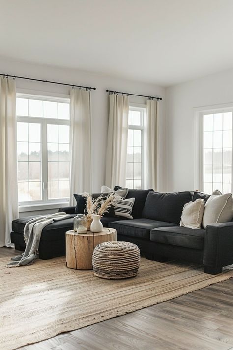 a living room filled with lots of furniture next to two large windows on top of a hard wood floor