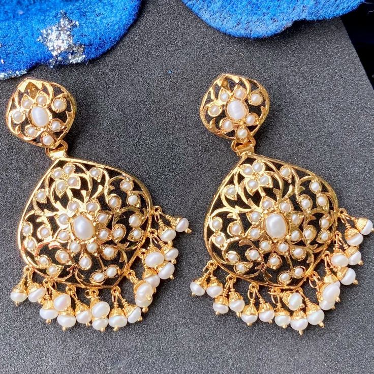 Discover the timeless beauty and elegance of pearls with our dainty, antique look pearl earrings. Made with high-quality, genuine freshwater pearls, these earrings add a touch of sophistication to any outfit and occasion. The golden hue of the pearls is accentuated by the intricate antique design, giving them a luxurious and exclusive appeal. With these pearl earrings, you'll radiate an air of refined taste and class. The earrings close with a threaded bombay screw. Luxury Gold Earrings With Pearl Charm, Festive Pearl Drop Jewelry For Anniversary, Luxury Gold Pearl Earrings With Pearl Charm, Luxury Gold Pearl Earrings With Charm, Luxury Pearl Embellished Earrings For Wedding, Luxury Pearl Drop Earrings For Wedding, Exquisite Gold Pearl Earrings, White Intricate Design Gold-plated Earrings, Elegant Pearl Embellished Chandbali Jewelry