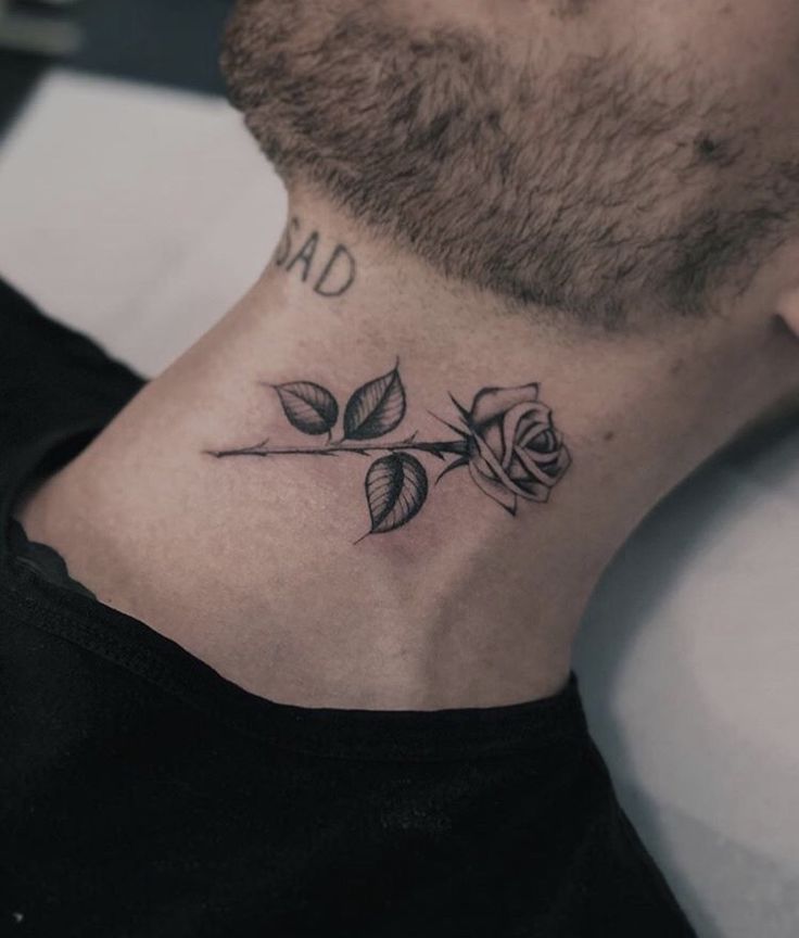 a man's neck with a rose tattoo on the top of his left side