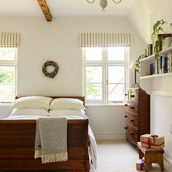 a bedroom with a bed, dresser and window