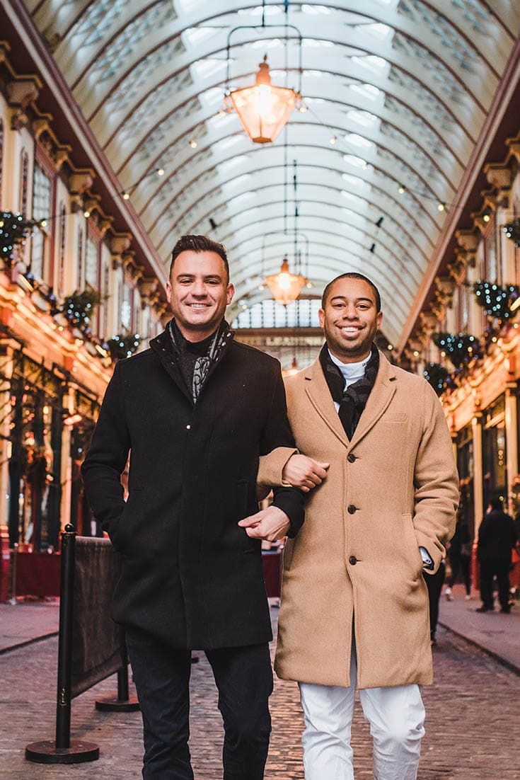 two men are walking down the street in an indoor shopping mall with christmas lights on the ceiling