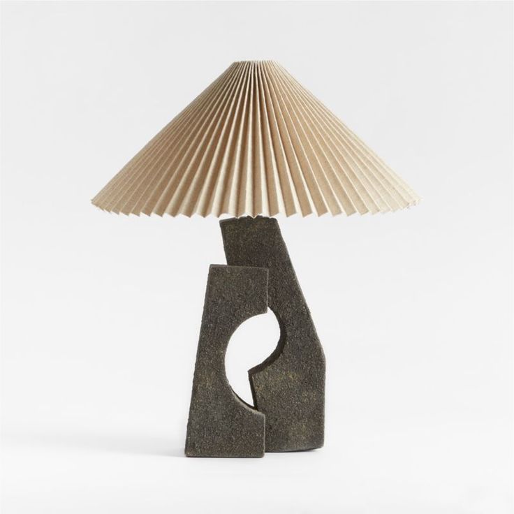 a lamp that is sitting on top of a wooden base with a paper shade over it