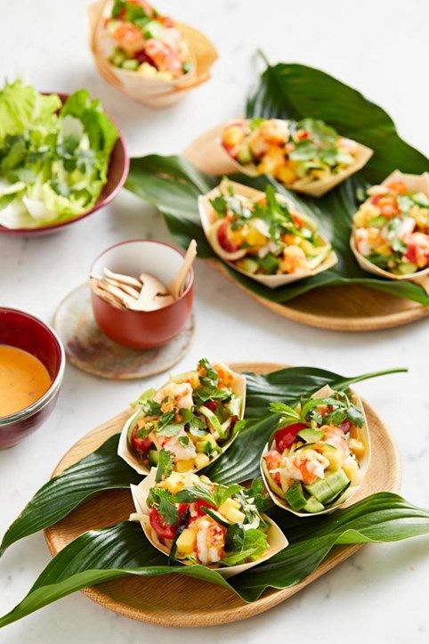 several small plates with food on them sitting on a table next to cups and sauces