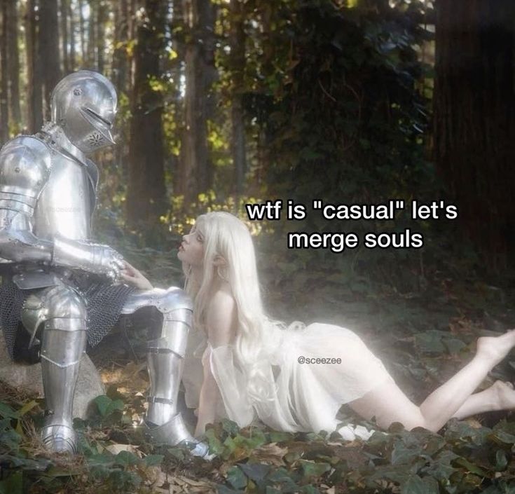 a woman laying on the ground next to a man dressed as a knight in a forest