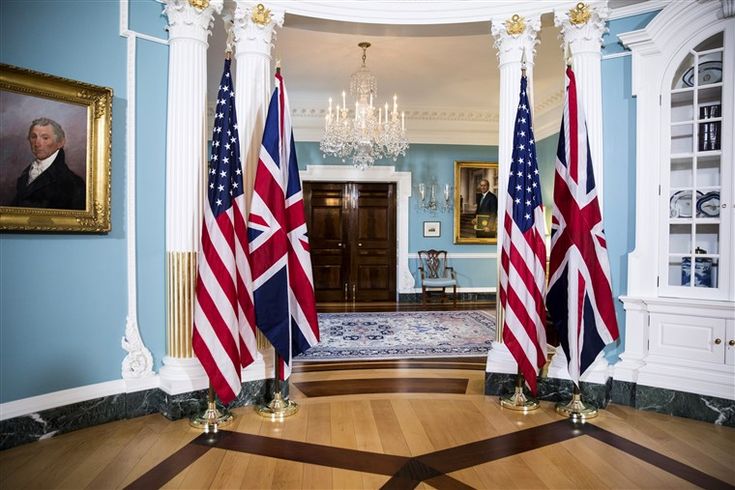 two flags are in the middle of a room with blue walls and chandelier