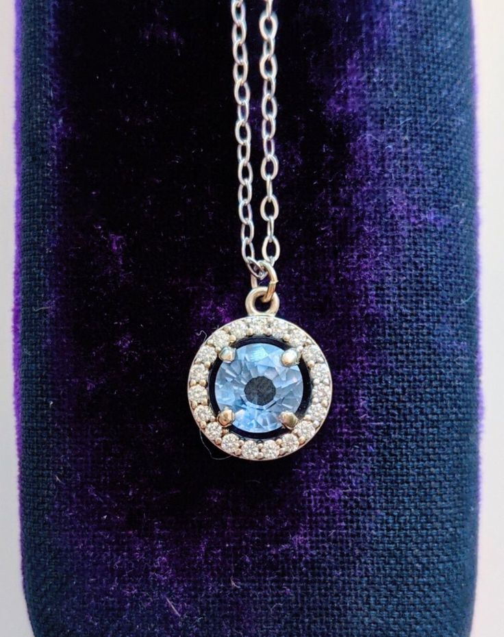 A gorgeous blue sapphire sparkles in the light, accented by a circle of diamonds. Set in 14k white gold, this is the prettiest sapphire necklace you may ever see! Handcrafted in 14k white gold Features a sapphire surrounded by a diamond halo Sapphire measures approx. 5.5mm in diameter Pendant measures approx. 10mm in diameter Full necklace hangs at 18" with a 14k lobster clasp Sapphire Jewelry With Brilliant Cut Round Stone, Elegant Blue Jewelry With Halo Design, Sapphire Necklaces With Halo Setting, Sapphire Cubic Zirconia Jewelry With Halo Design, Sapphire Jewelry With Halo Design And Round Cut, Sapphire Halo Design Jewelry In Cubic Zirconia, Sapphire Halo Design Jewelry With Round Cut, Blue Sterling Silver Jewelry With Halo Design, Lab-created Sapphire Round Necklace For Gift