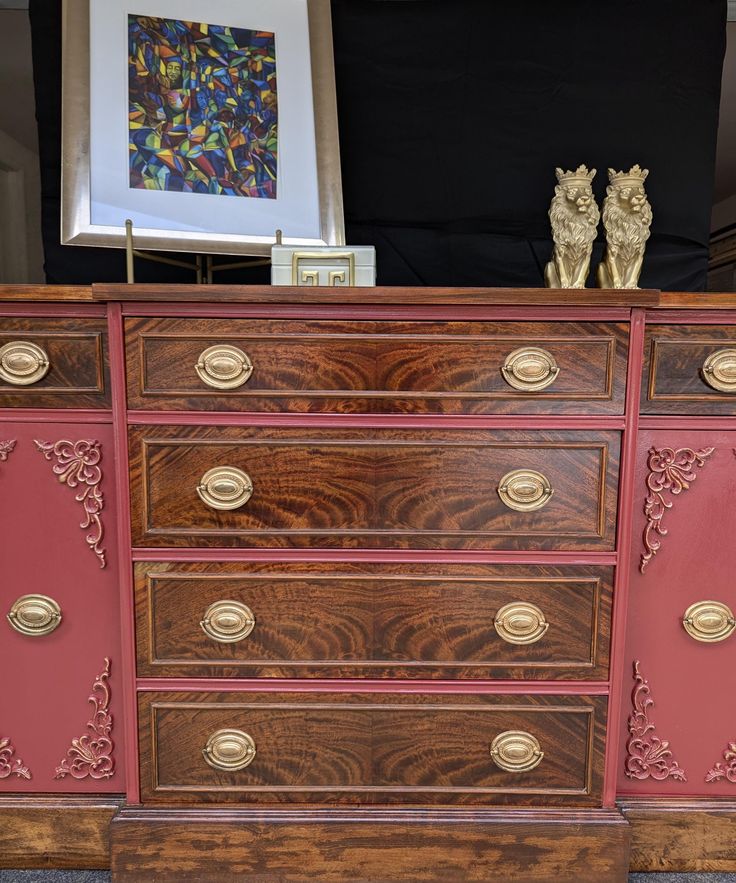 an old dresser has been painted red and gold