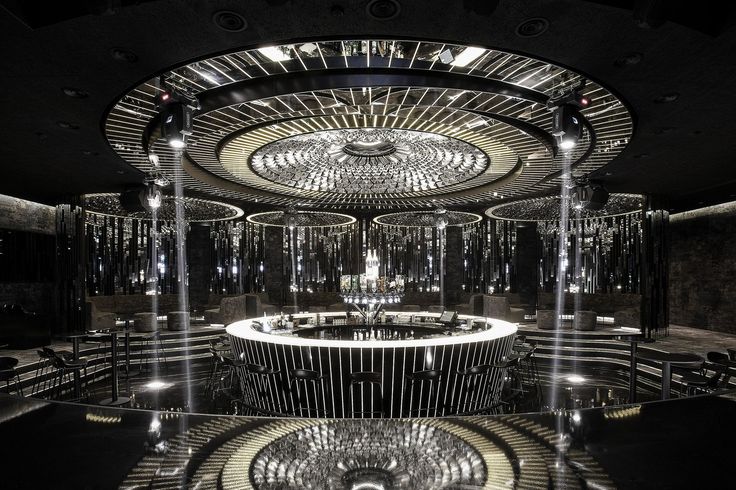 an artisticly designed room with circular mirrors and chandeliers in the center is lit by lights