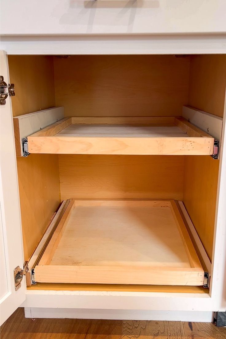 an open cabinet with wooden shelves on the bottom and one shelf in the middle is empty