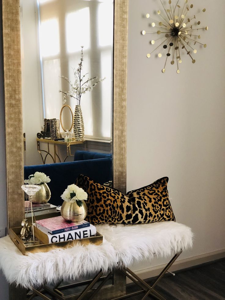 a living room filled with furniture and a large mirror on the wall over a bench