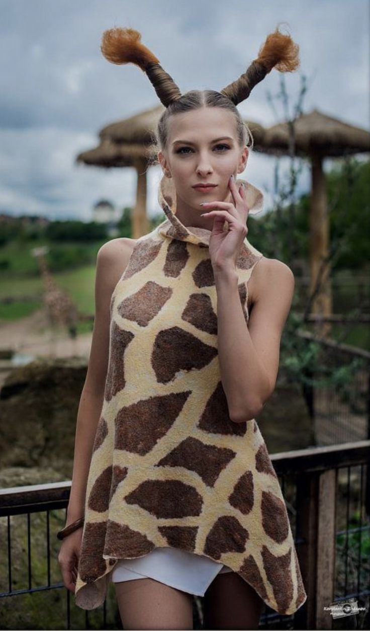 a woman in a giraffe print top with horns on her head