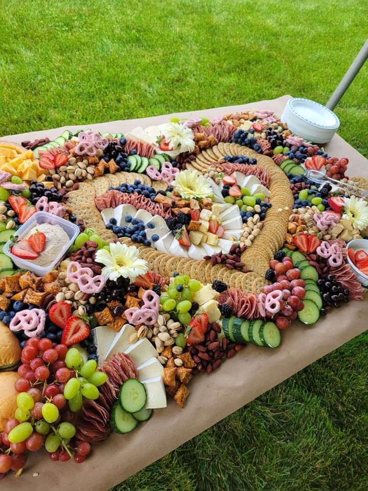 a table topped with lots of assorted fruits and veggies on top of a grass covered field