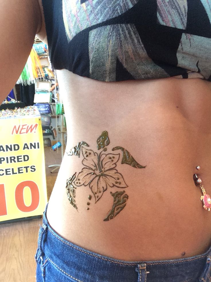 a close up of a person with a flower tattoo on their stomach and the bottom half of her stomach