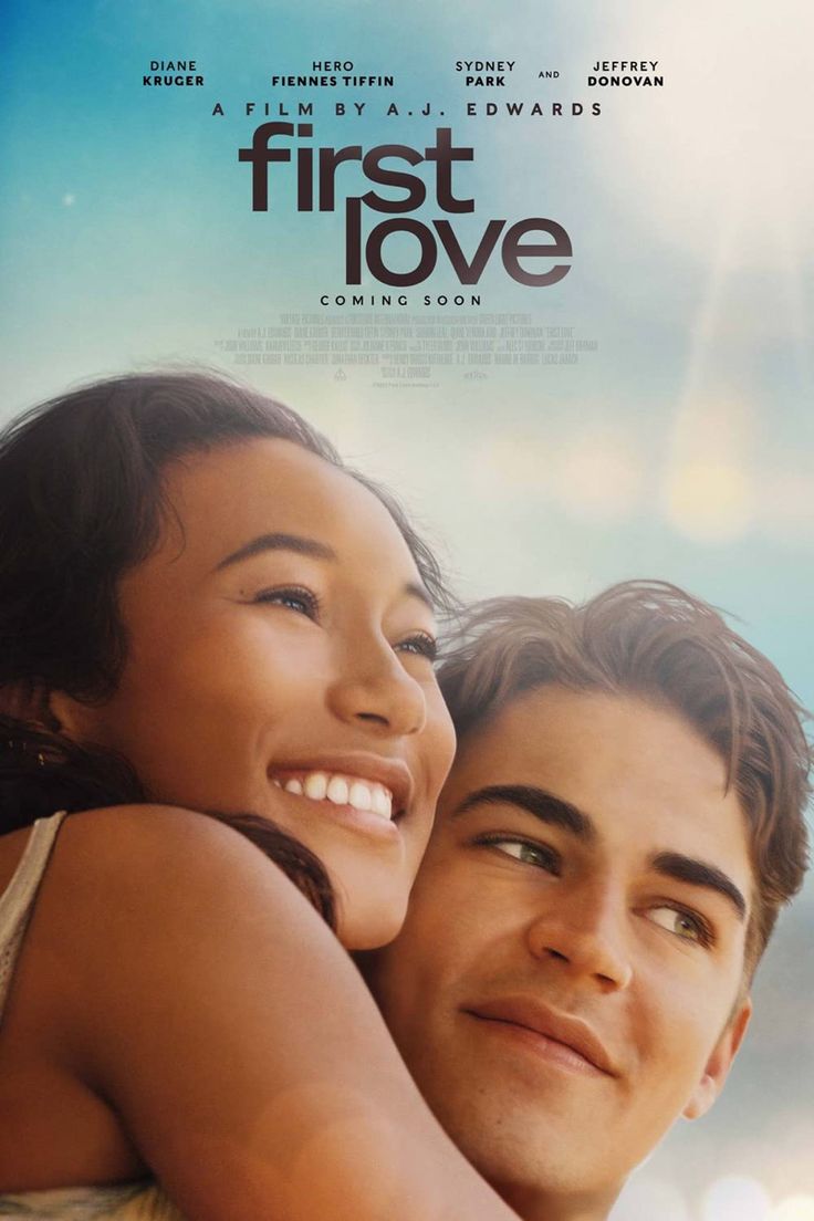 a man and woman hugging each other in front of a poster for the movie first love