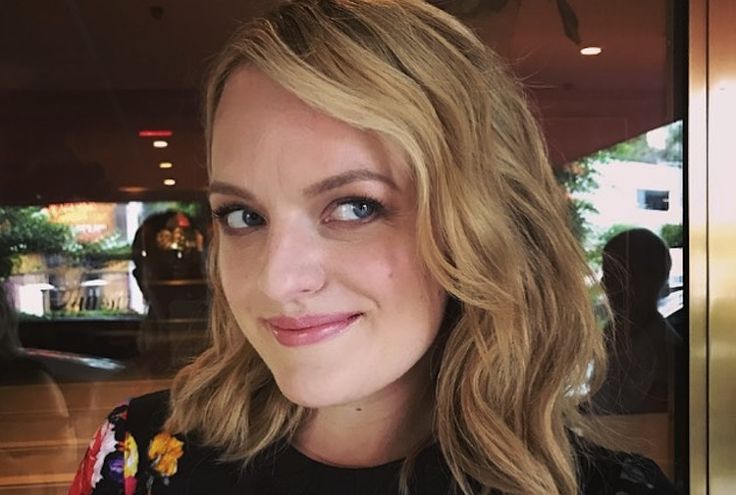 a woman with blonde hair and blue eyes is smiling at the camera while holding a donut