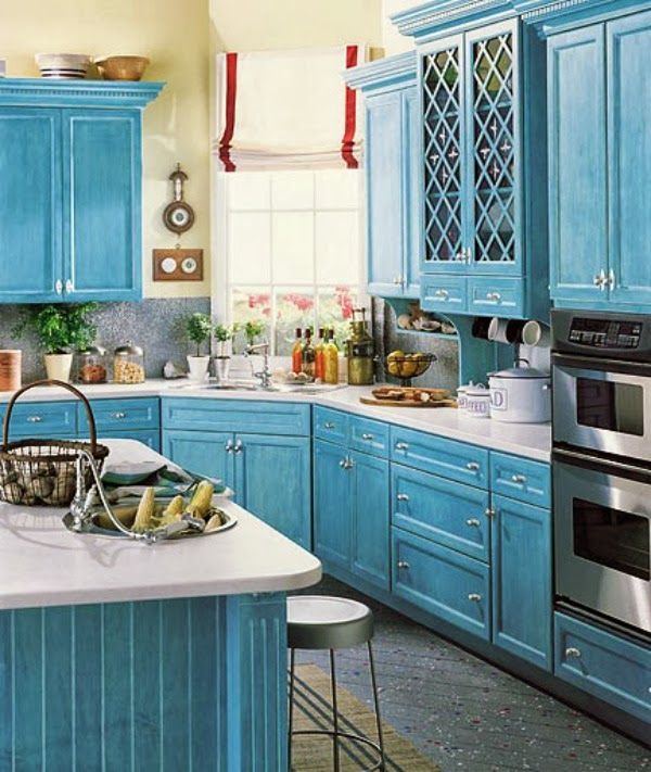 a kitchen with blue cabinets and white counter tops