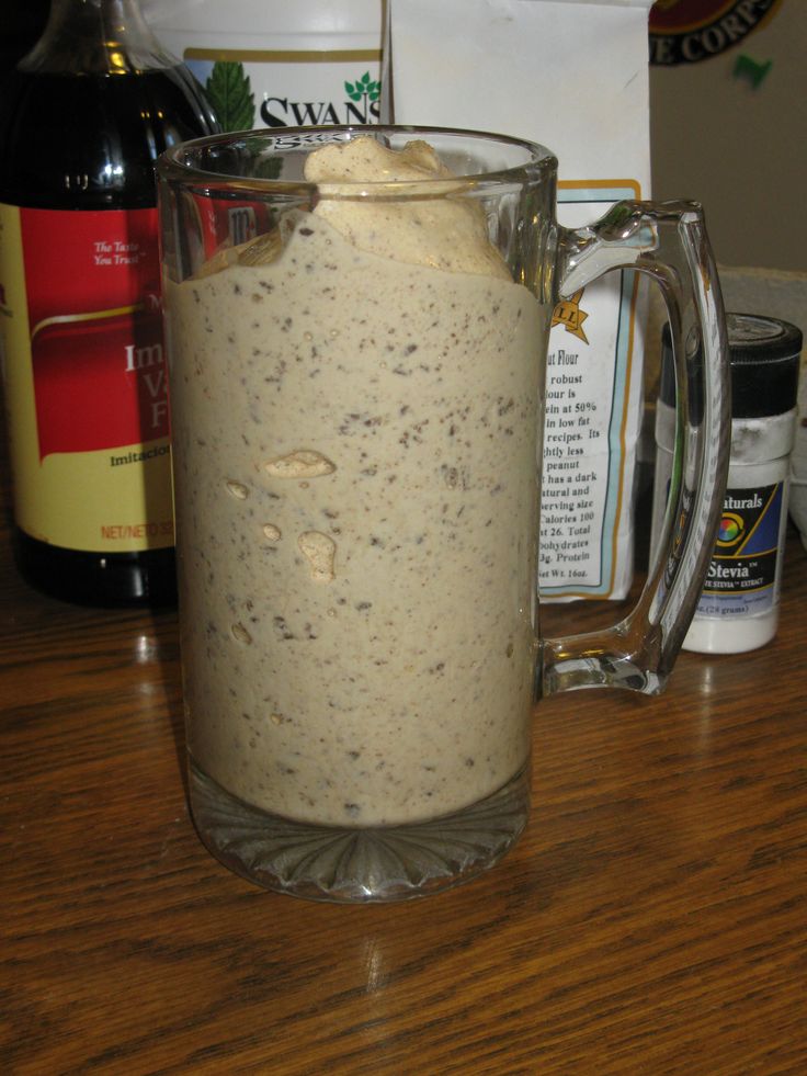 a glass pitcher filled with liquid sitting on top of a wooden table