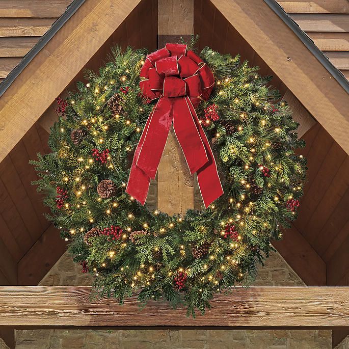 a christmas wreath with lights and a red bow