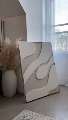 a white vase sitting on top of a hard wood floor next to a large mirror