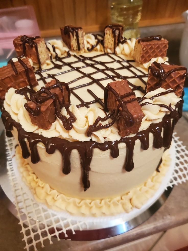 a cake with white frosting and chocolate drizzles