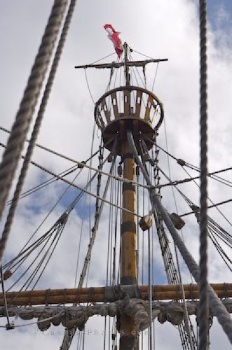 the mast of an old sailing ship with ropes