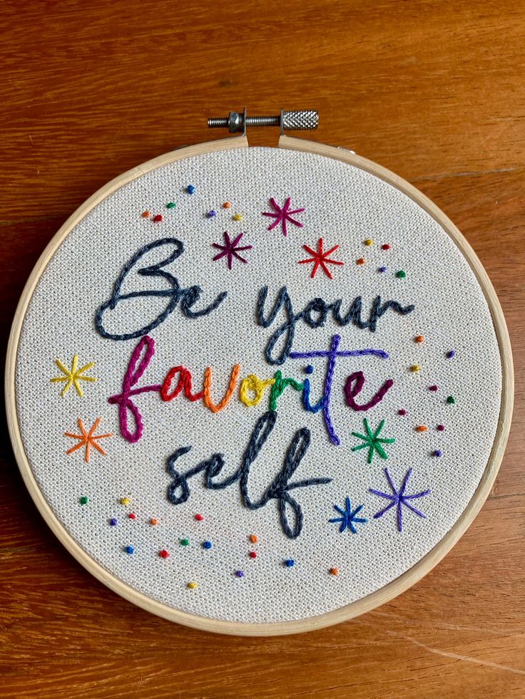 an embroidered hoop with the words be your favorite self on it, and stars in multicolors