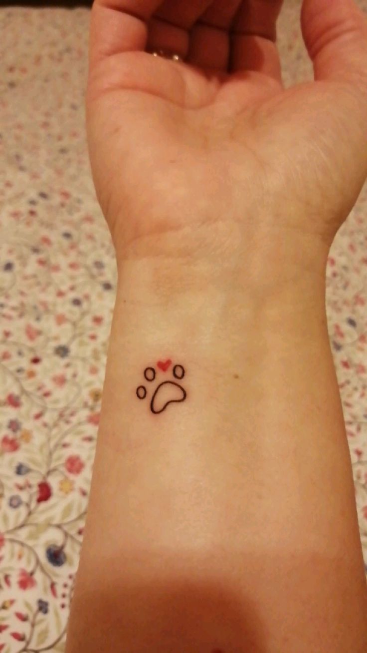 a woman's wrist with a small tattoo on it