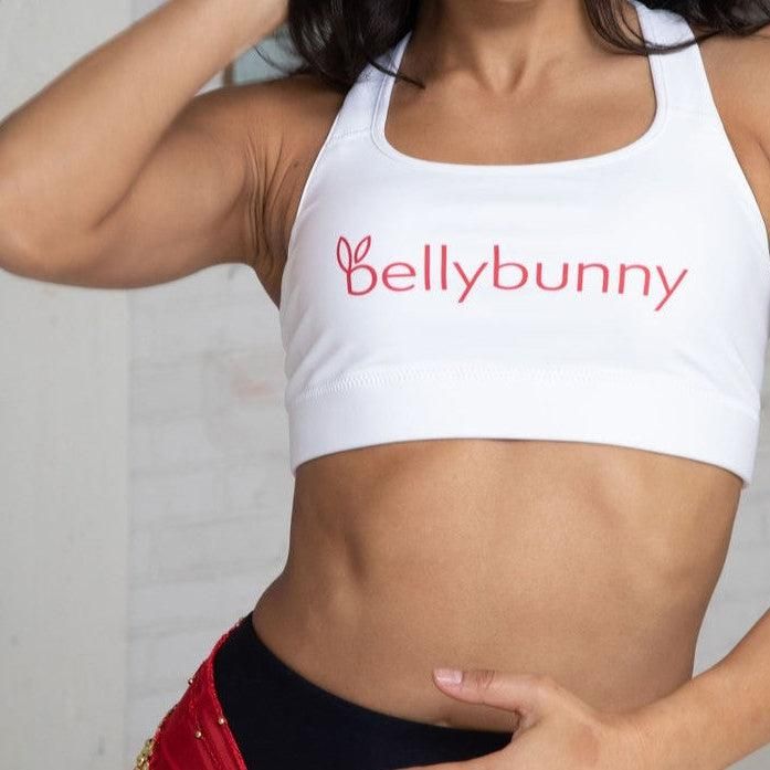 Our signature white sports bra with red logo boasts a scoop neck and a racerback for a secure fit. Constructed with a moisture-wicking fabric that stays dry during low to moderate intensity activities, it's the perfect choice for dance or gym classes. Team it with Bellybunny leggings and hoodie for a super cute and comfortable look! Logo M, Getting Ready To Move, Red Sports Bra, Rainbow Logo, Bra Size Guide, Gym Classes, White Sports Bra, Classic Style Women, Women's Sports