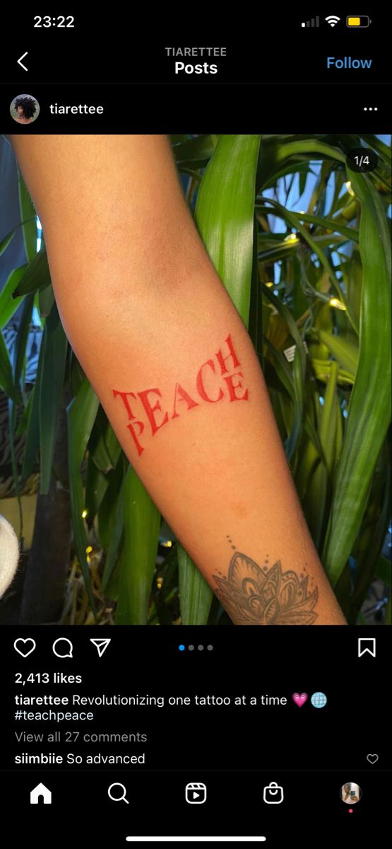 a person with a tattoo on their arm and the word peace written in red ink