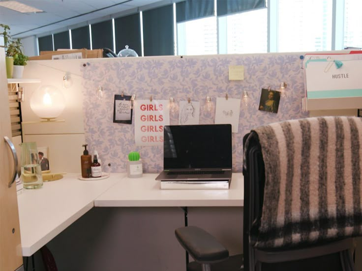 an office cubicle with a laptop on the desk