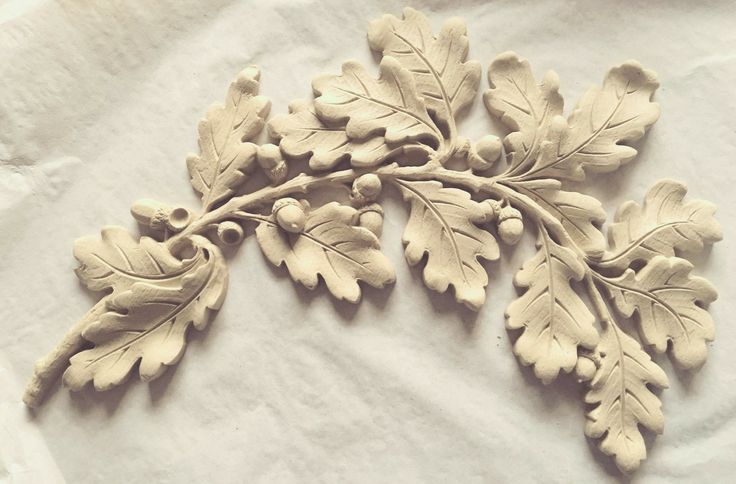 a close up of a leaf and acorn decoration on a white sheet with paper