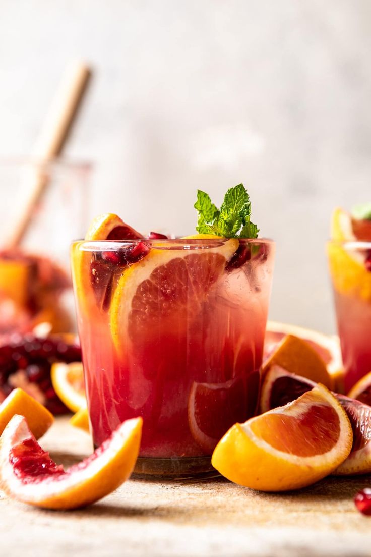 an orange cocktail is served in glasses with garnish