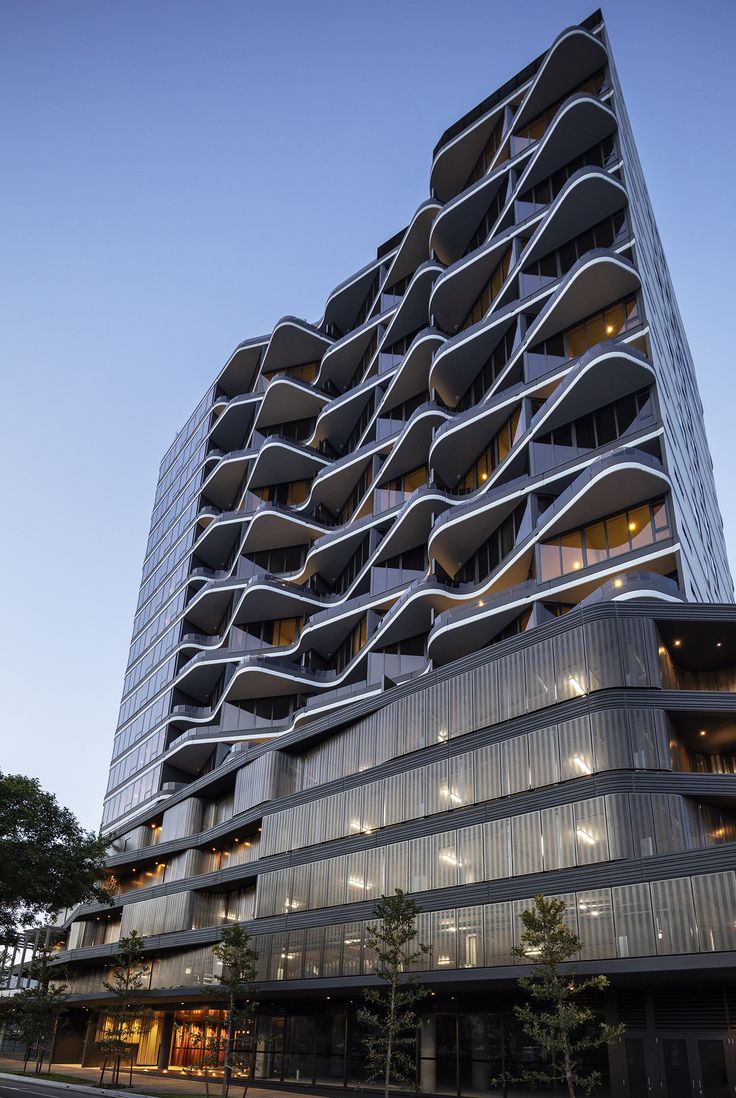 a tall building with many balconies on it's sides at night time