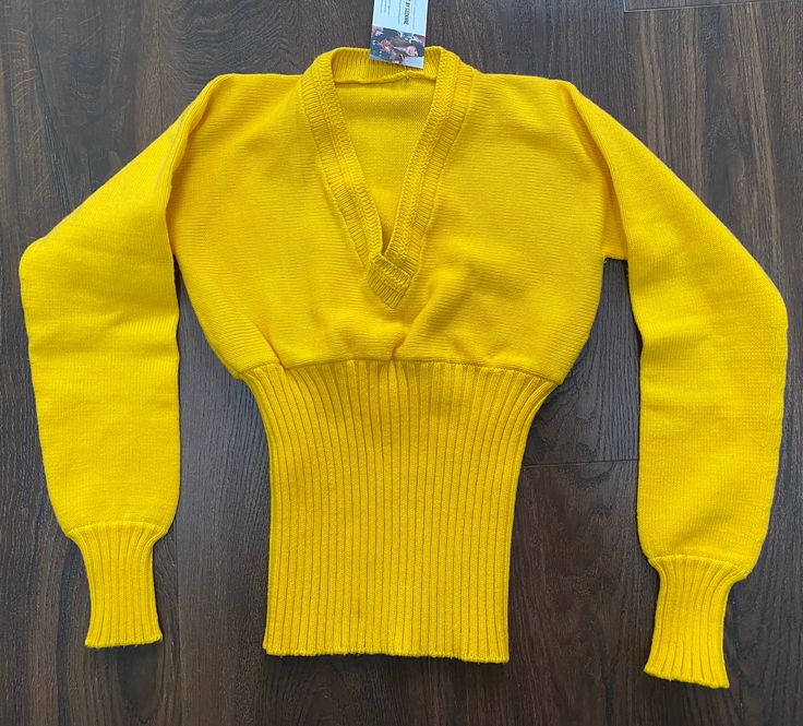 Sunny yellow sweater with deep v-neck and ribbed lower waist/cuffs. This piece has flaws that I didn't catch prior to washing. There are some dark marks/lines on the back waist, sleeve and back. Please see photos. Sold as presented. Please see further details below. Label - none No fabrication contents label but feels like cotton or acrylic.  Should fit a size extra small but please refer to measurements below as I am unable to offer returns.  Shoulder seam to shoulder seam - no shoulder seams A Yellow Knit Sweater, Knit Sweater Top, Long Sleeve Jumper, Yellow Knit, Dark Mark, Sunny Yellow, Winter Sweater, Yellow Sweater, Top Vintage