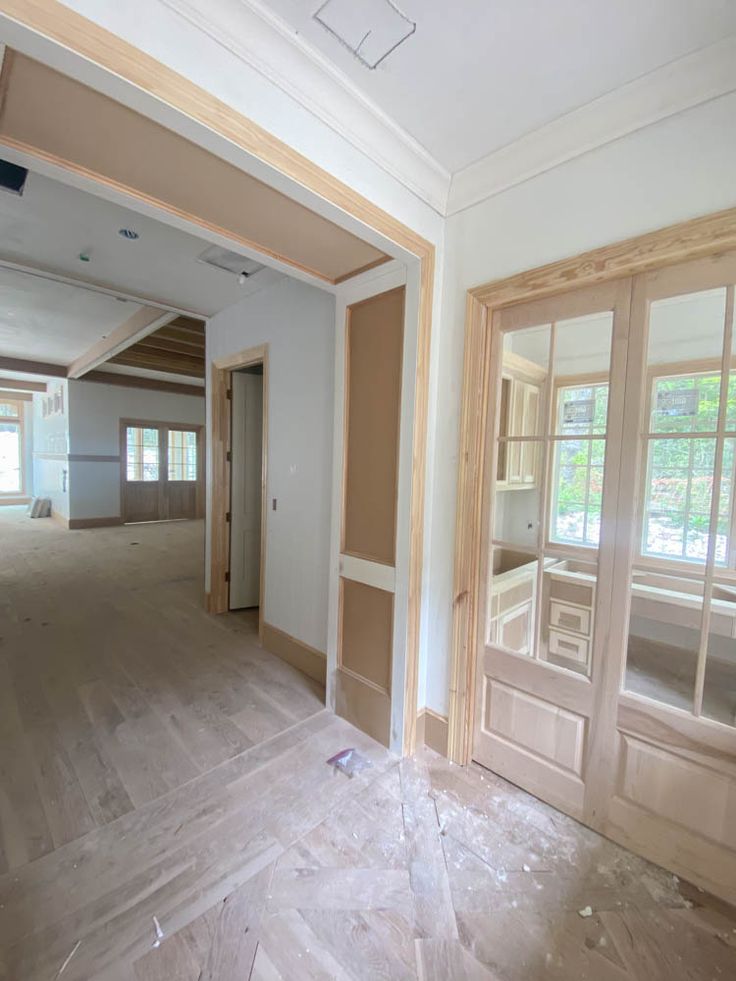 an empty room with wooden floors and large windows