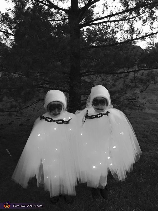 two people dressed in ghost costumes standing next to each other